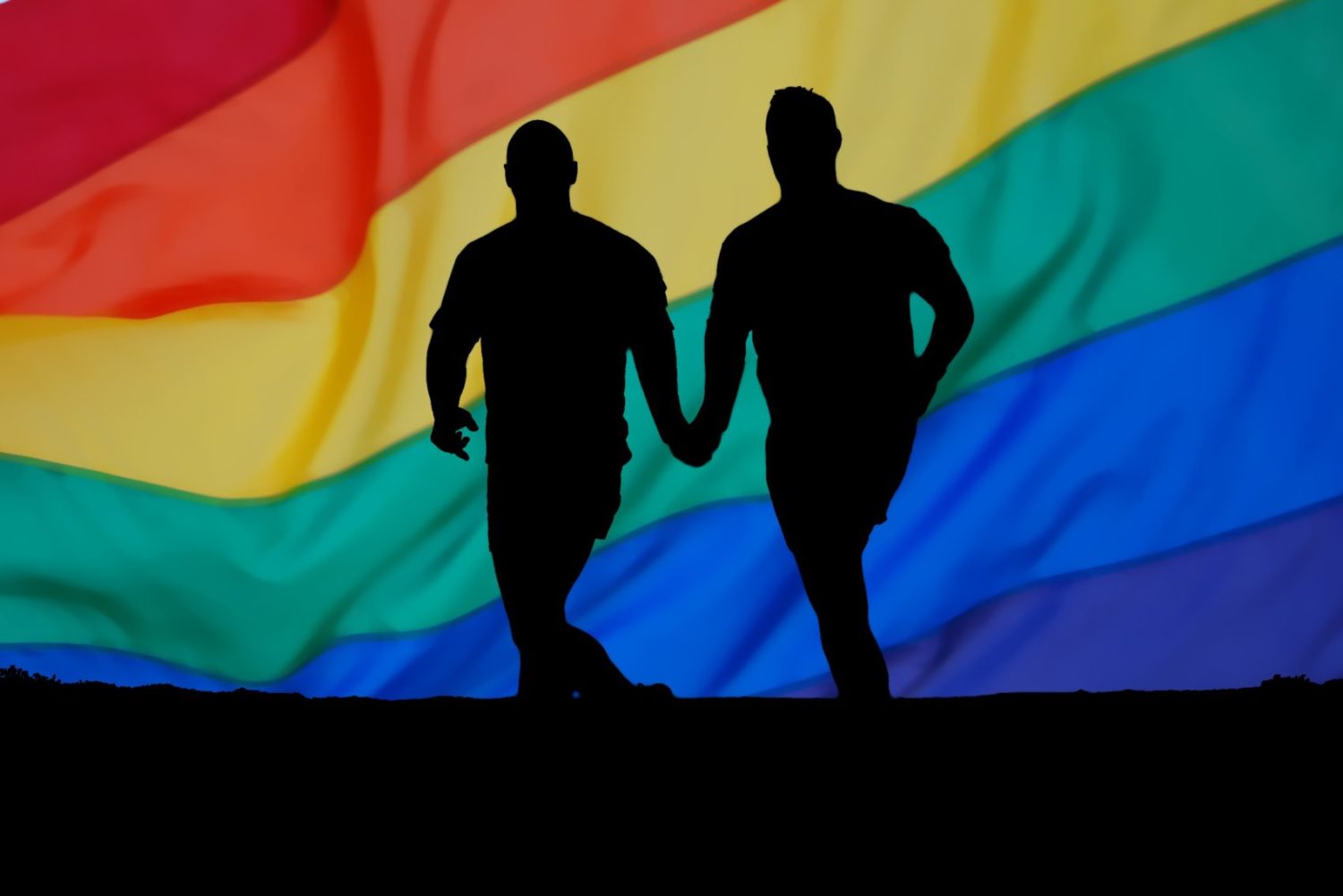 Zwei schwule Männer vor Regenbogenflagge